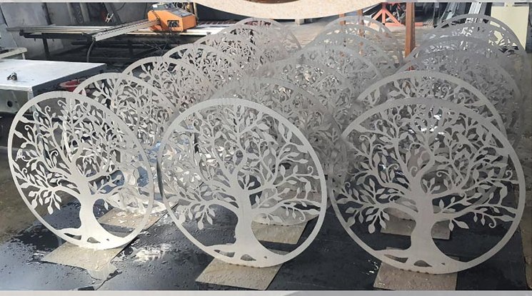 Arbres de vie en acier brut alignés dans l'atelier