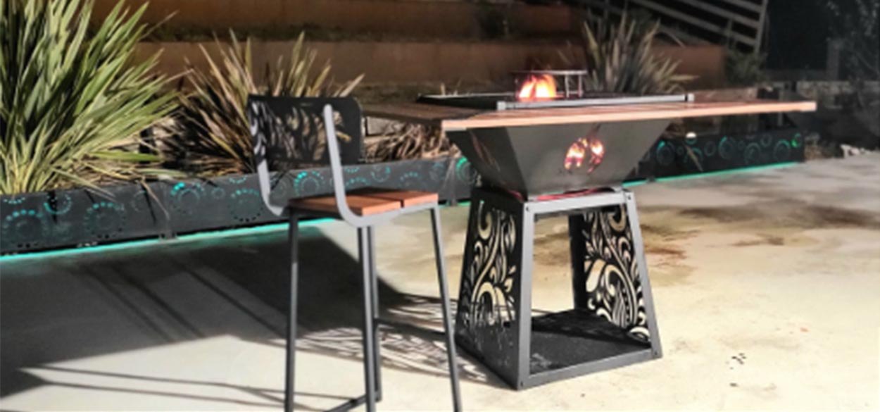 Brasero carré de 100 cm en peinture noire avec mange-debout en bois, feu allumé