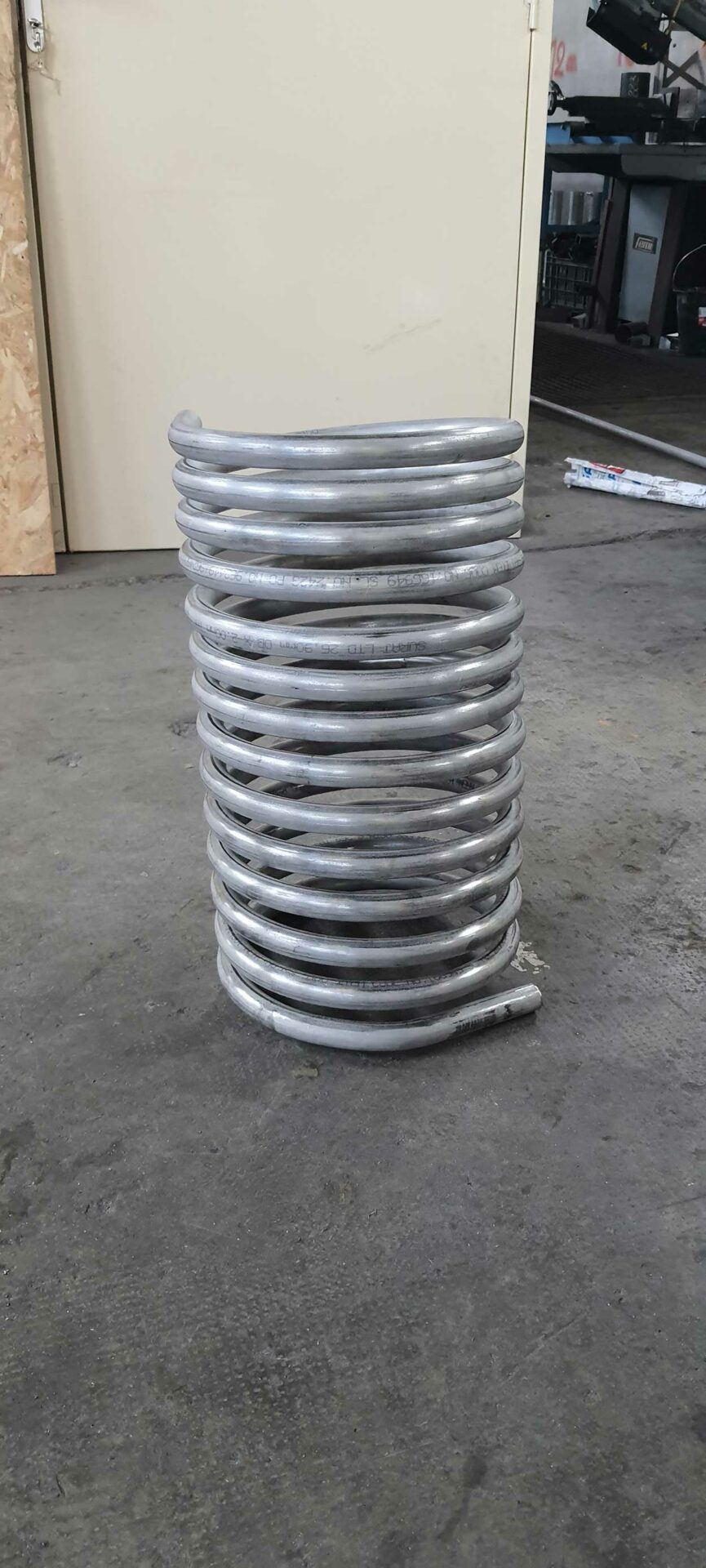 Serpentin en tube inox posé au sol de l'atelier